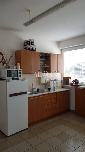 Kitchen interior with cabinets, microwave, refrigerator, and sink in warehouse and hall spaces.