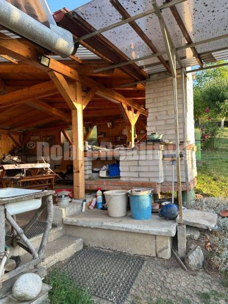 A cottage in Studená dolina in Levice with a wooden pergola and a brick grill.