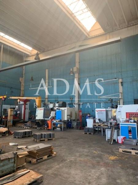 Production equipment in indoor warehouse and hall spaces with industrial machines.