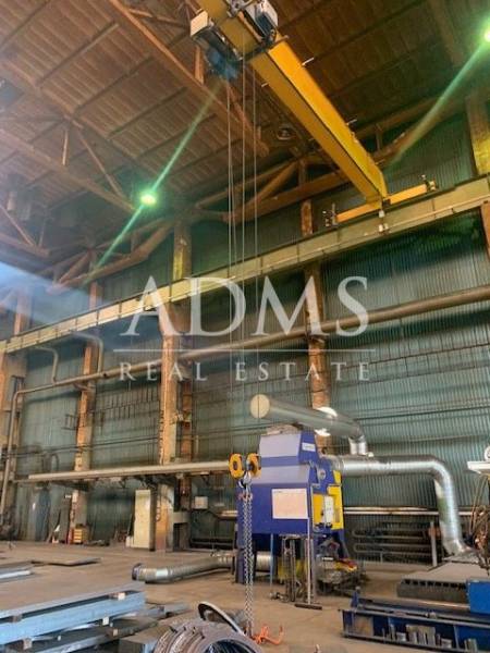 Industrial interior with equipment and a crane in warehouses and halls.