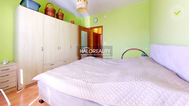 Bright bedroom in a 3-room apartment with a large wardrobe and green walls.