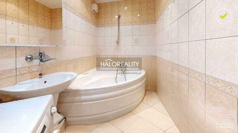 A bathroom with a corner bathtub and a sink in a 3-room apartment.