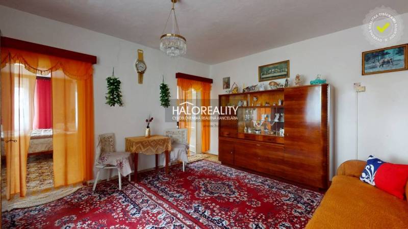 Family house with a living room, wooden display cabinet, curtains, and decorative elements.