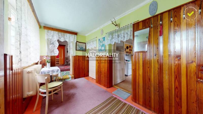Interior of a family house with wooden paneling and lace curtains.
