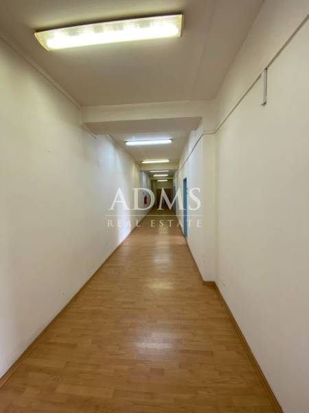 A long corridor with wooden floors and white walls in offices.