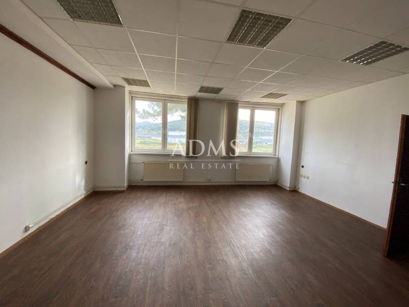Office space with a dark floor and a window with a view.
