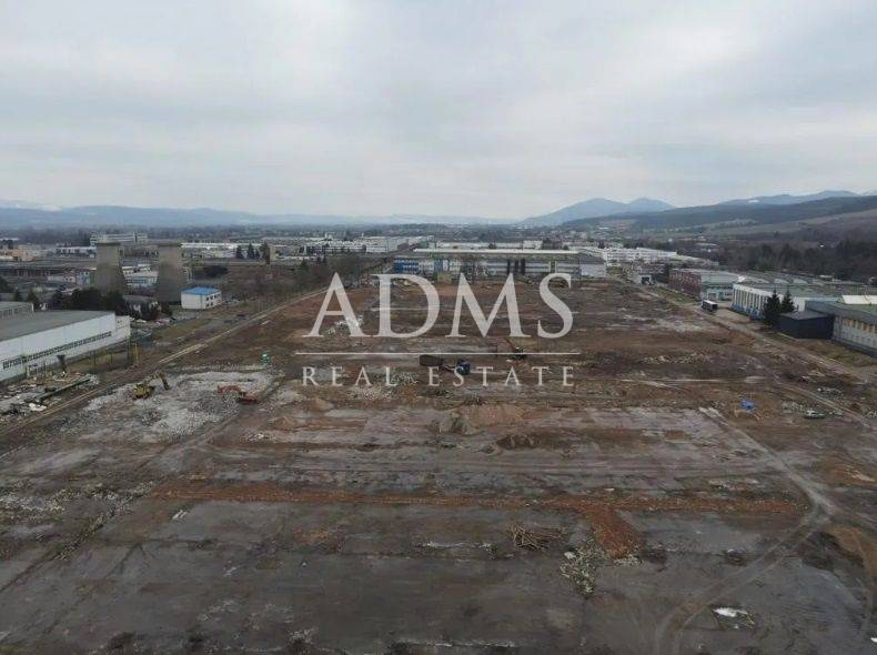 A construction site in the commercial area of Dubnica nad Váhom with industrial buildings in the background.