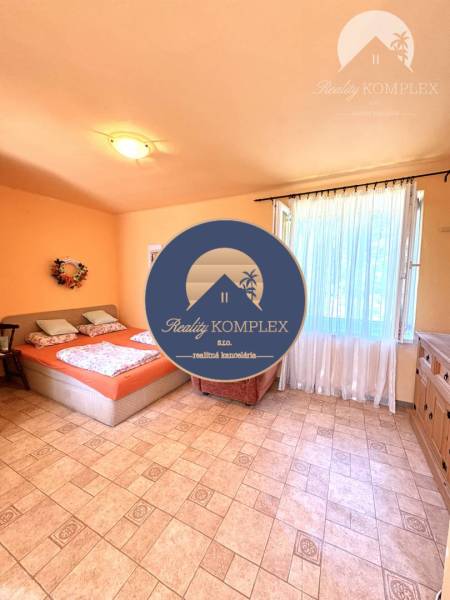 A bright room in a cabin with a double bed and a wardrobe.
