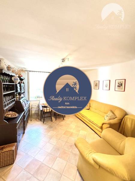 A living room in a cottage with comfortable yellow sofas and wooden furniture.