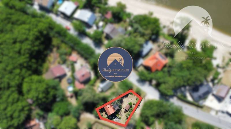 Aerial view of a cottage in Radvaň nad Dunajom with surrounding nature and buildings.