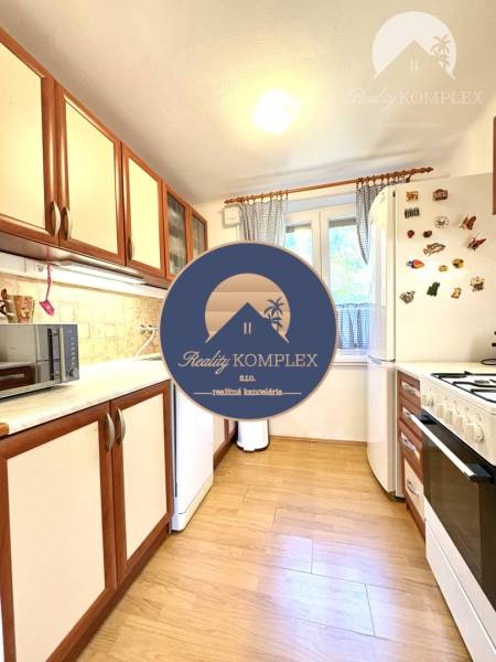 A kitchen in a cottage with light wooden furniture and appliances.
