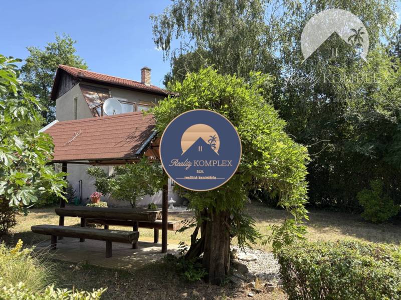 A cottage in Radvaň nad Dunajom with a garden seating area and surroundings full of greenery.