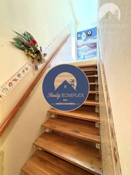 A wooden staircase in a cottage with decorative details on the walls.