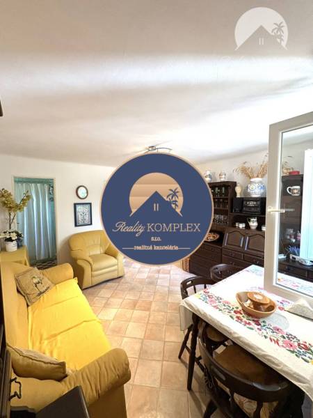 Living area with a sofa and dining table, a cottage with comfortable and functional furnishings.