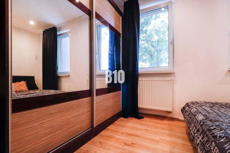 Bedroom in a 3-room apartment with a large wardrobe, window, and bed.