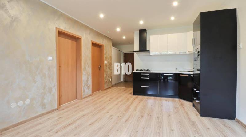 Interior of a 3-room apartment with a bright kitchen and wooden flooring.