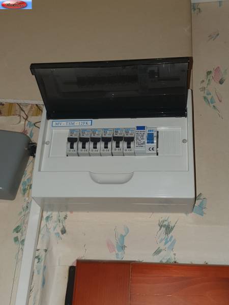 A fuse box in a 2-room apartment, located on the wall near the ceiling.