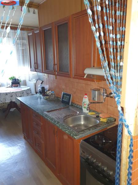 A kitchen with a wooden cabinet and appliances in a 2-room apartment.