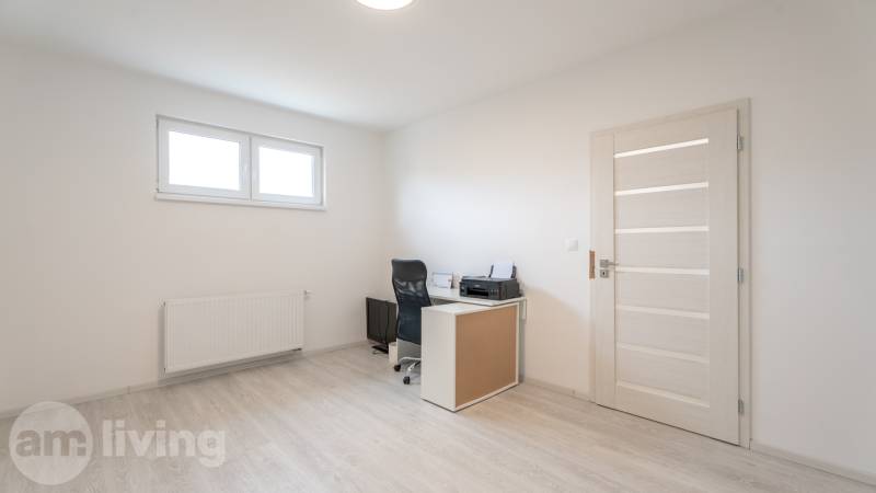 A room in a 3-room apartment with a desk, chair, and window.