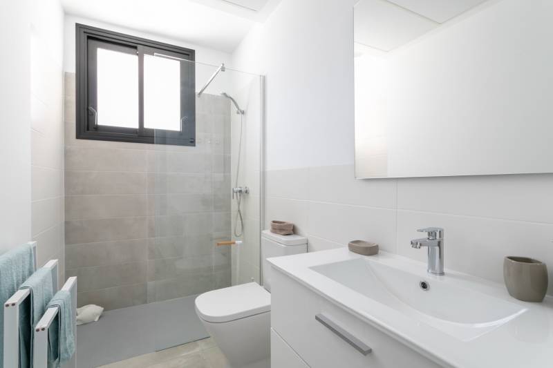 Bathroom in a villa with a modern shower cabin and white furniture.