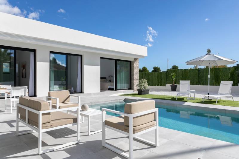 Villa in Calasparra with a pool and a relaxation area on the terrace under a parasol.