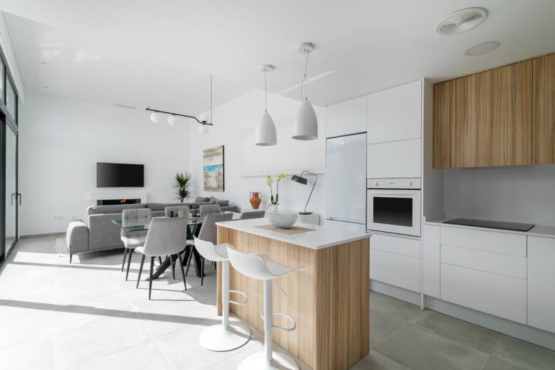 Spacious kitchen in the villa with an island, dining table, and modern appliances.
