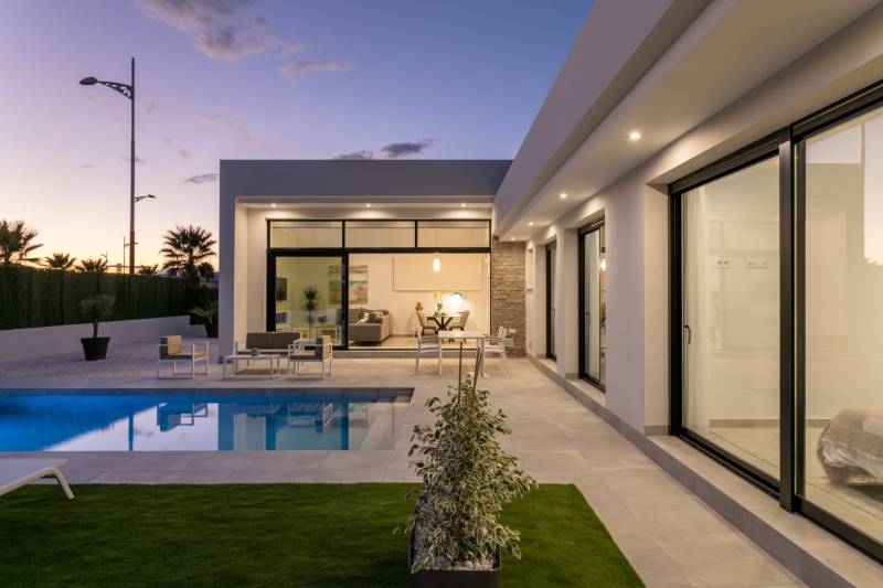 The exterior of the villa in Calasparra with a garden, pool, and terrace at sunset.