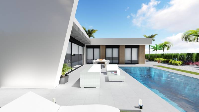 A terrace with a pool at a villa in Calasparra, surrounded by palm trees and greenery.