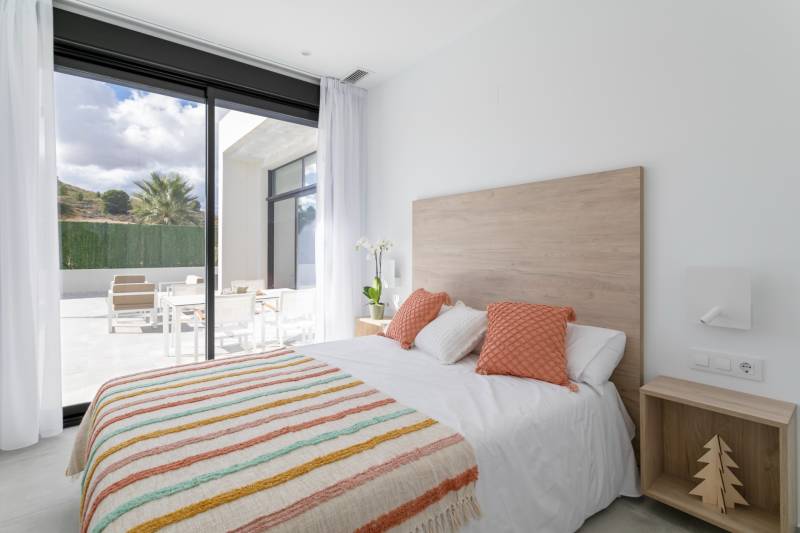 Bedroom in a villa with a view of the terrace, soft colors, wooden details.
