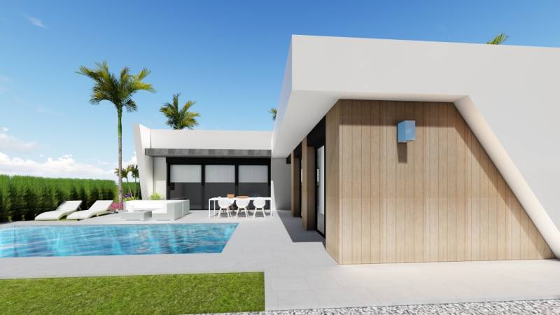 A pool and loungers at a villa in Calasparra, surrounded by a lawn and palm trees.