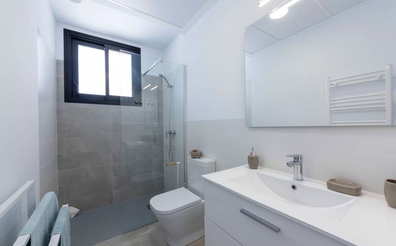 Bathroom in a villa with a sink, toilet, shower, and large mirror.