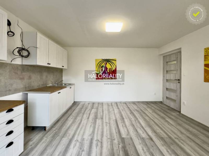 Interior of a family house with a kitchen unit and an abstract painting on the wall.