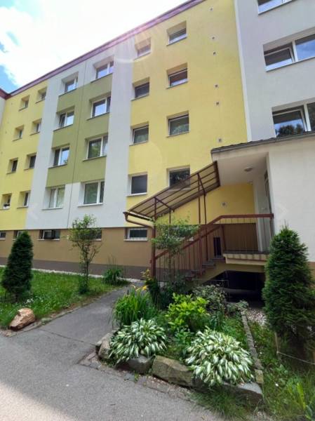 Apartment building on Tulska Street in Banska Bystrica with a colorful facade and flower bed.