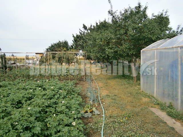 Garden on a residential plot in Jasová with a greenhouse and cultivation area.