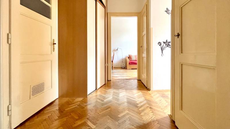 Hallway in a 2-room apartment with wooden doors and parquet flooring.