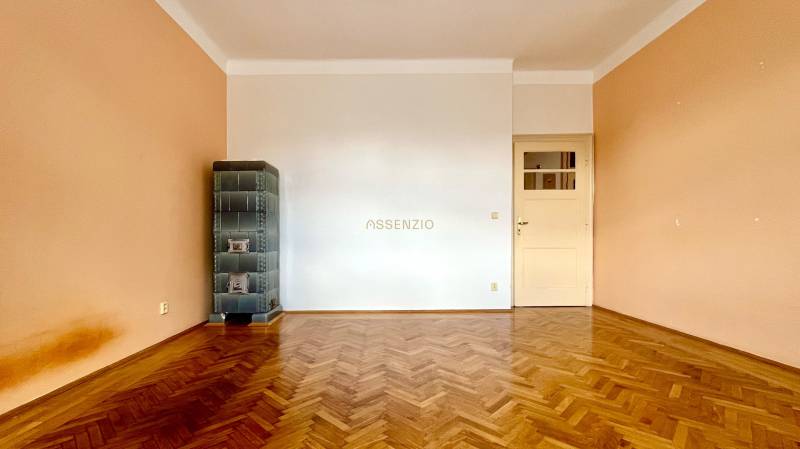 A room with a parquet floor and a tiled stove in a two-room apartment.