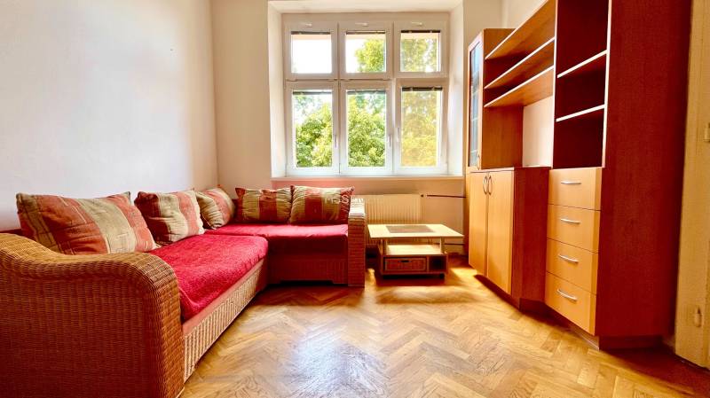 Wooden floor, corner sofa with red upholstery, living room set, window with a view.
