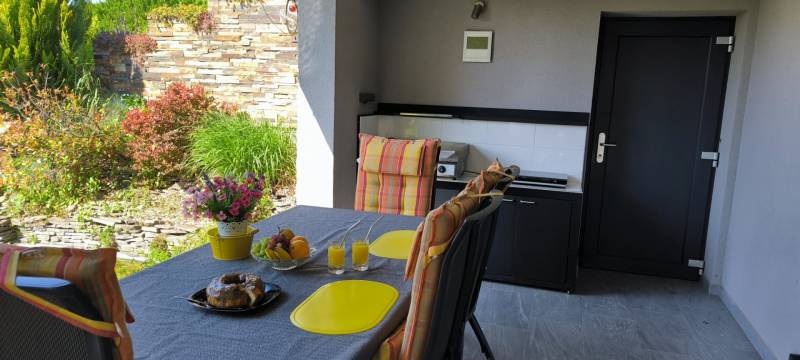 A family house with a garden and terrace, a set table, and greenery in Zurndorf.