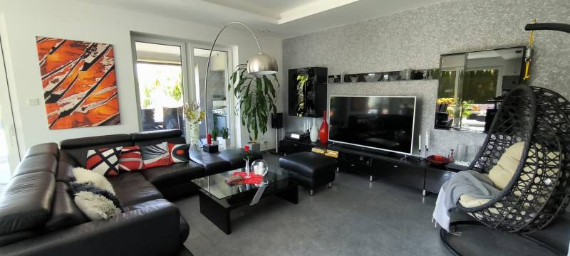 Living room in a family house with a leather sofa, television, and modern decor.