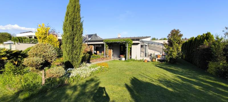 The garden of a family house in Zurndorf with a gazebo and various ornamental plants.