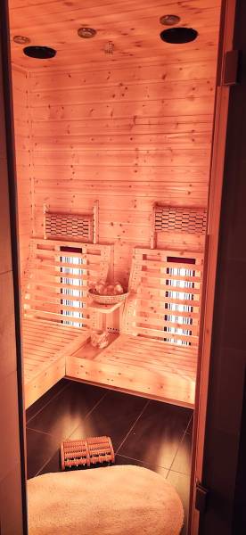 Interior of a family house with a wooden sauna and lighting, with seats for relaxation.