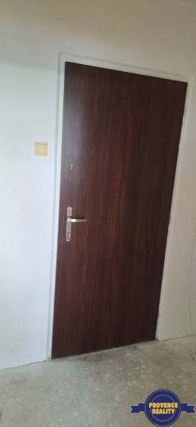 Wooden door with a metal handle as part of a 3-room apartment.