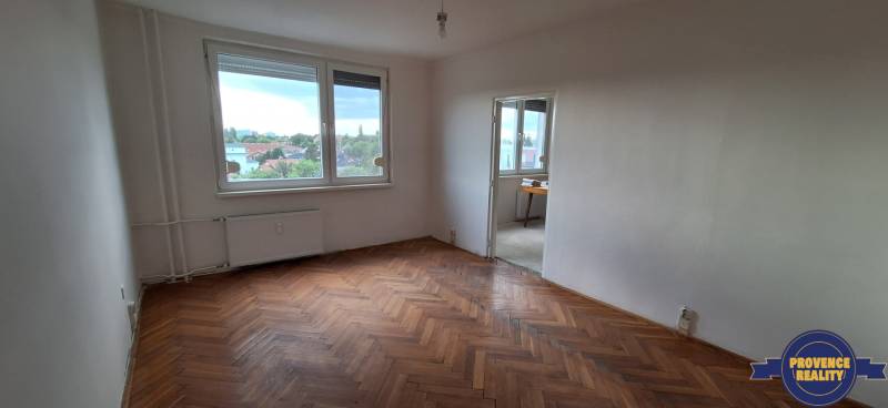 Spacious room with parquet flooring in a 3-room apartment, city view.