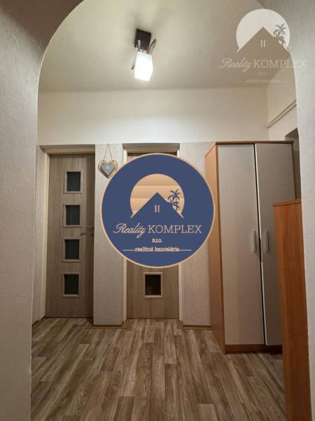 A hallway in a family house with laminate flooring, a wardrobe, and a ceiling light.