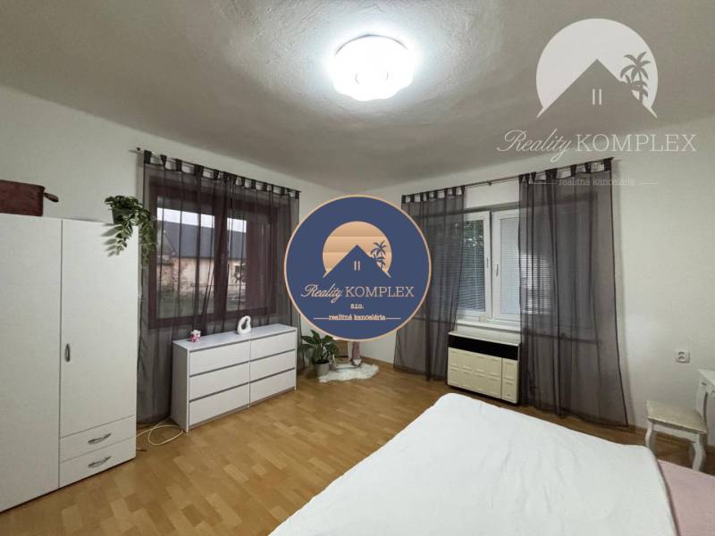Bright room in a family house with wooden flooring and furniture.