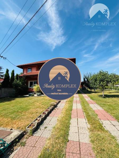A family house in Trávnik with a well-maintained garden and a paved walkway.