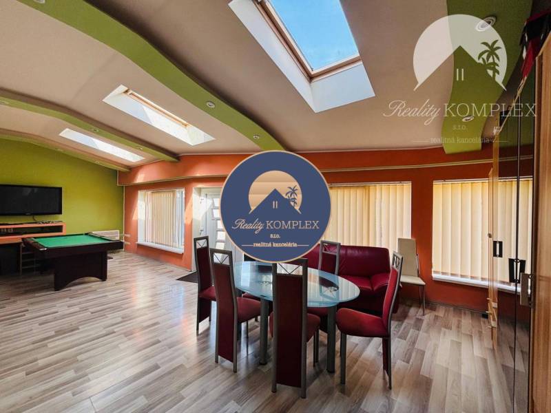 Interior of a family house with a seating area, pool table, and skylights.