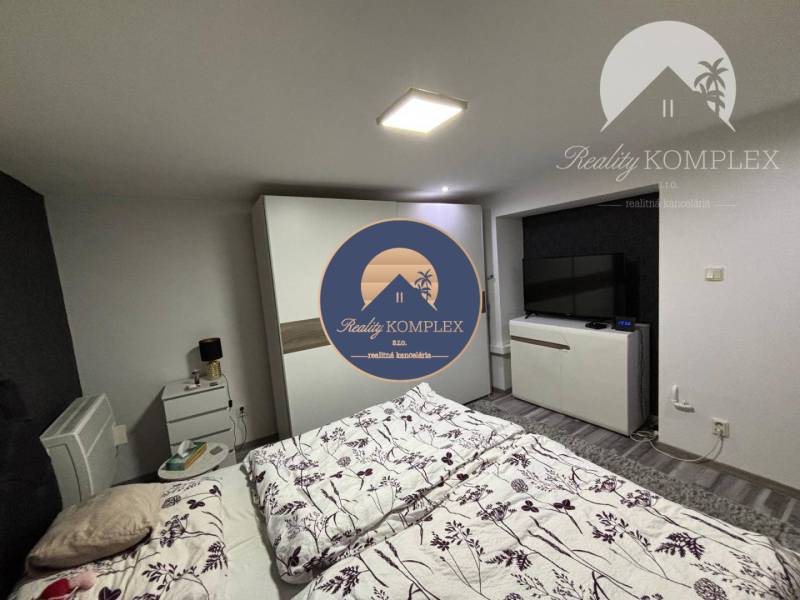 A bedroom in a family house with a double bed, a wardrobe, and a television.