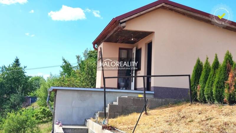 A house with a garden in Lučenec, surrounded by greenery and a blue sky.