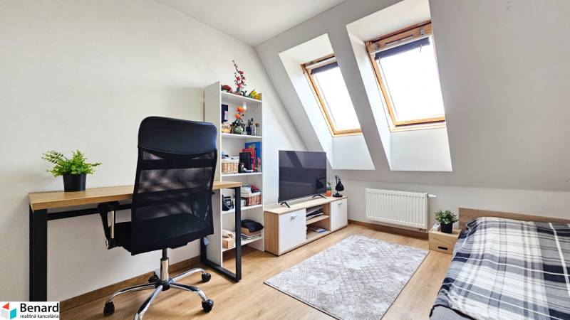 A desk with a black chair, a television, and a shelf in a 4-room apartment.